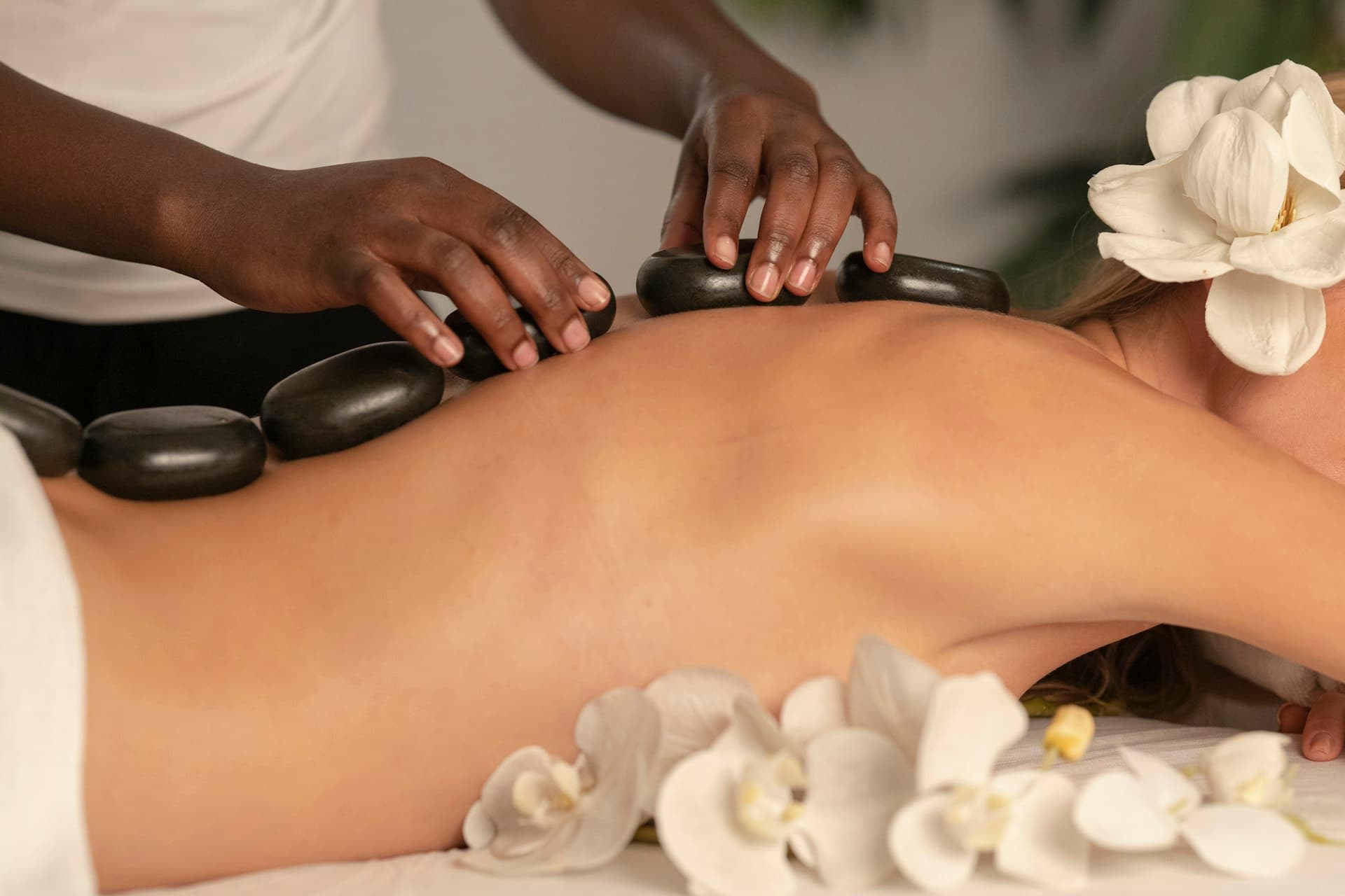 Hot stone massage with orchid flowers